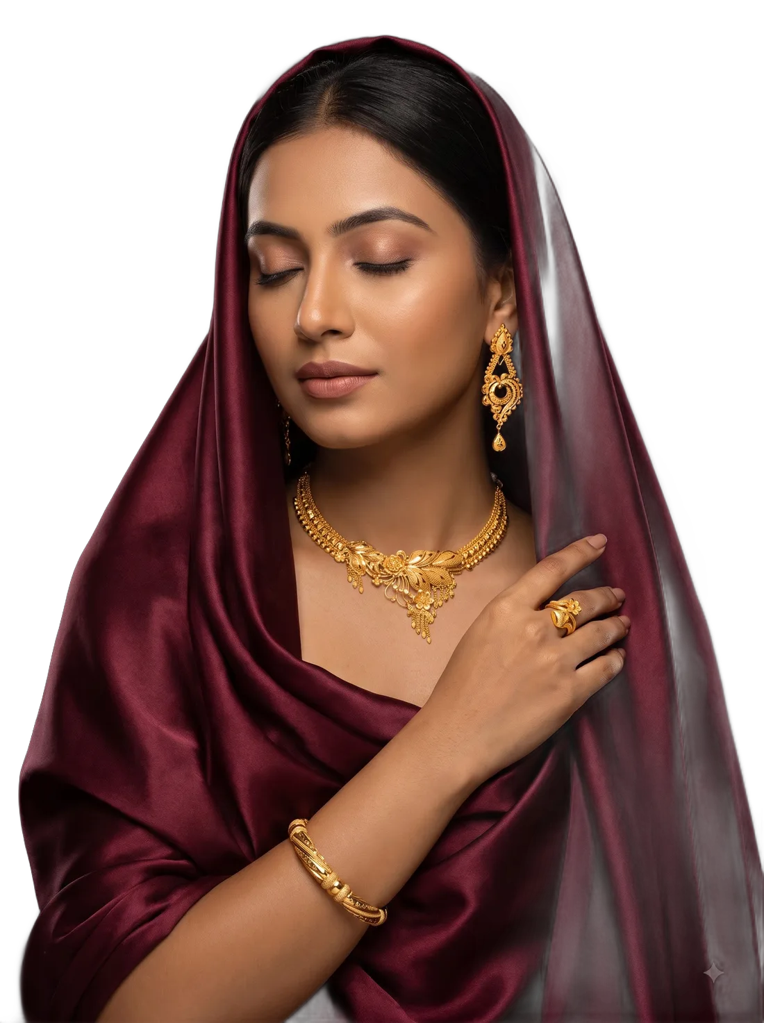 A woman in a deep red silk headscarf with her hand at her shoulder, wearing gold drop earrings, a collar necklace, a ring and a pair of bangles.